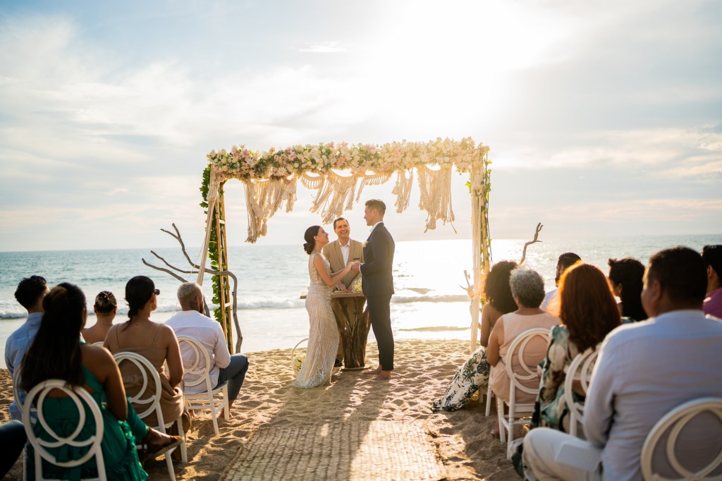 Groom and bride at the wedding ceremony on the beach